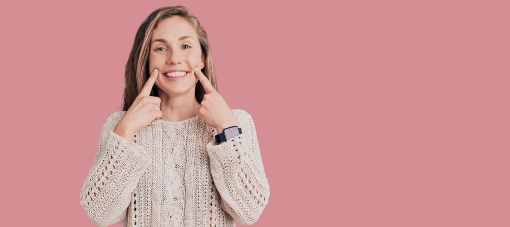 woman smiling pink background why choose smile makeover